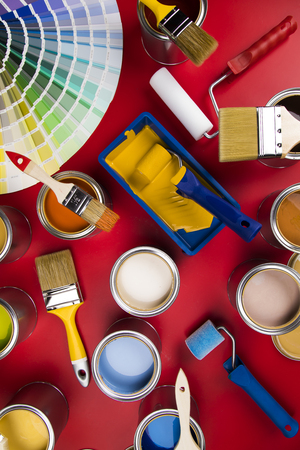 Buckets full of rainbow colored oil paint, red backgroundの写真素材
