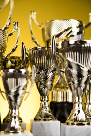 Cups of winners award on white podium, sport backgroundの写真素材