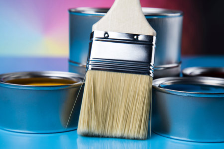 Paintbrush on cans with color