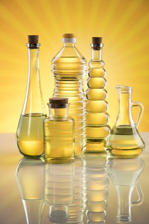 Olive oil, rapeseed oil, sunflower oil on sunburst orange backgroundの写真素材