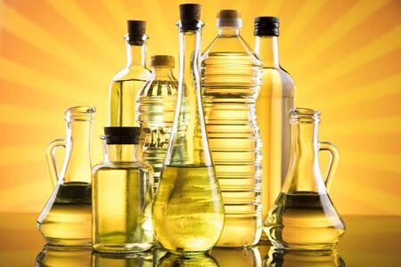 Olive oil, rapeseed oil, sunflower oil on sunburst orange backgroundの写真素材
