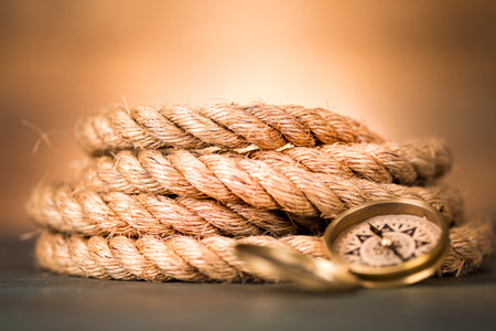 Compass and rope on a wooden background. Toned image.の写真素材