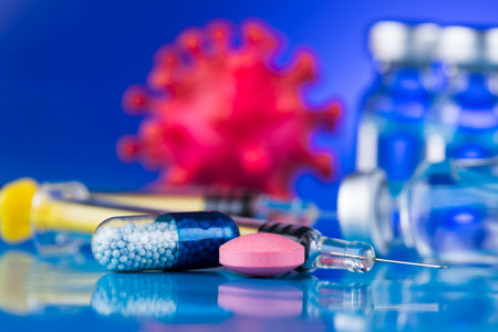 Vaccine, syringe, ampoules and virus on blue backgroundの写真素材