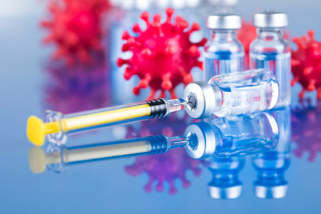 Coronavirus vaccine concept. Syringe and vials on blue background.の写真素材
