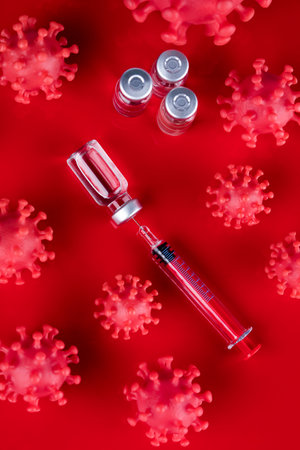 Vaccine and syringe on red background. Coronavirus conceptの写真素材