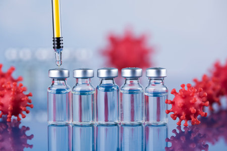 Coronavirus vaccine vials and syringe on blue backgroundの写真素材