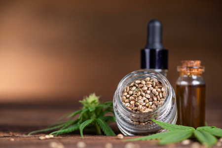 Cannabis oil in a glass bottle with hemp seeds on wooden backgroundの写真素材