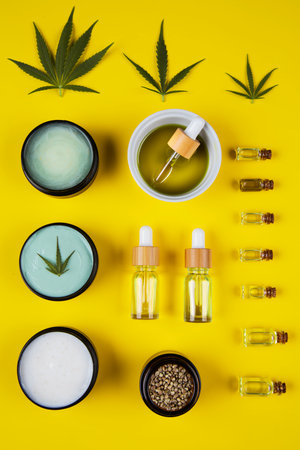 Cannabis essential oil in a glass bottle on a yellow background.の写真素材