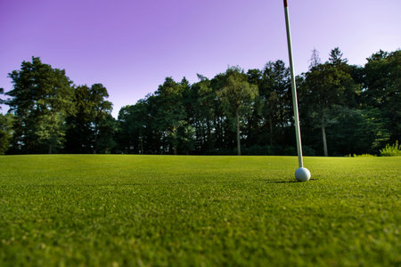 Golf ball and clubs in golf field