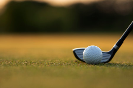 Playing a golf on a beautiful sunset in the eveningの写真素材