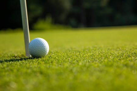 Golf ball and clubs in golf fieldの写真素材