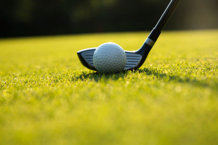 Playing a golf on a beautiful sunset in the eveningの写真素材