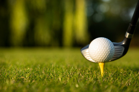 Golf player playing in a golf club on a beautiful sunset in the eveningの写真素材
