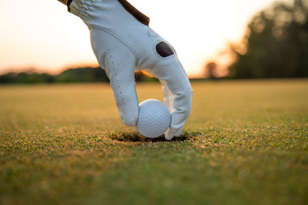 Golf course with ball and grass on close up of a hand ,grass,golfer,golfing,sky,nature,ball,object,play,blue,fairway,closeup,club,outdoor ,competition,recreation,background,color,summerの写真素材
