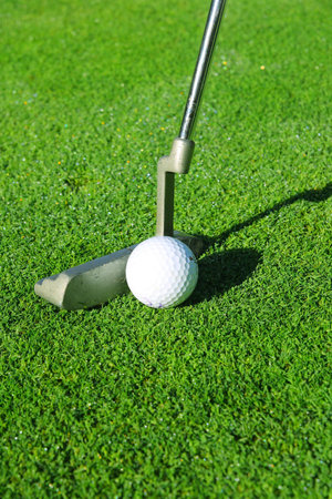 Golf ball and putter on a green