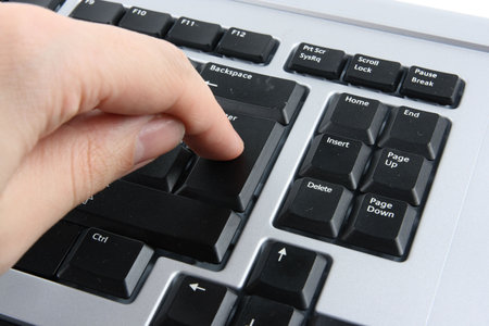 Finger pressing enter on black computer keyboard