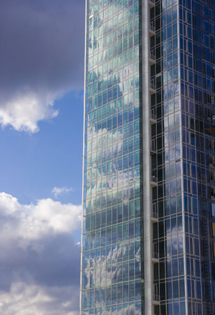 Detail of modern Prague office building mirroring blue sky and clouds