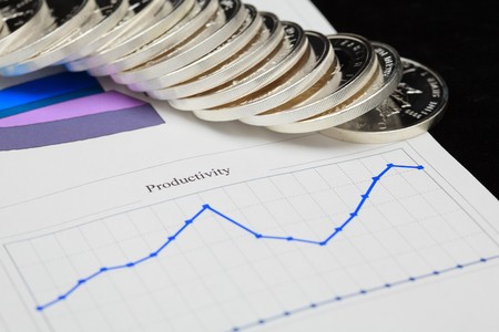 report with diagrams and silver coins on itの写真素材