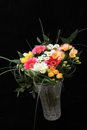 Bunch of many different flowers in crystal cut vase on black backgroundの写真素材