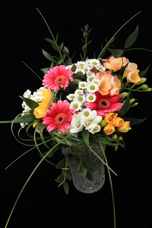 Bunch of many different flowers in crystal cut vase on black backgroundの写真素材