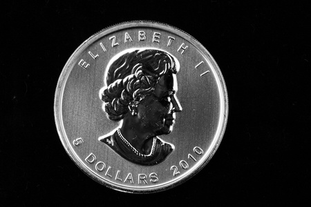Canadian maple leaf silver coin isolated on a black backgroundの写真素材