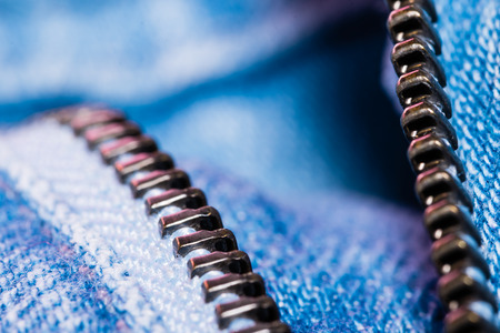 A closeup view of fastener of light blue jeans. Good visible texture and pattern.の写真素材
