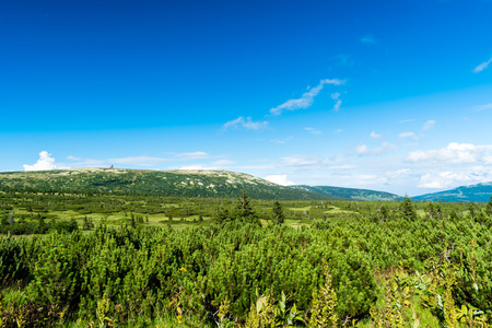 Beautiful mountain landscape and meadows on summer sunny day. Nice blue cloudy sky. The view from mountains in Krkonose National Park.の写真素材