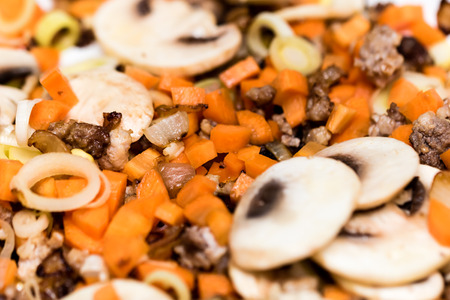 Roasted vegetables on cooking pan. Carrots, mushrooms, leeks, meat.の写真素材