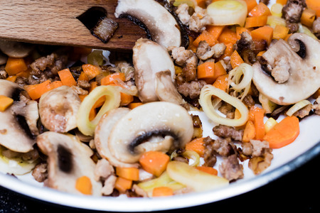 Roasted vegetables on cooking pan. Carrots, mushrooms, leeks, meat.の写真素材