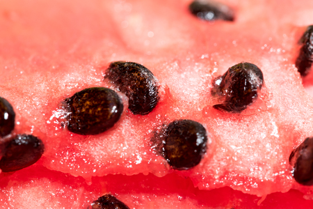 Close-up red fresh watermelon with black seeds. Healthy sweet tropical vegetable in detail, vibrant red colors.の写真素材