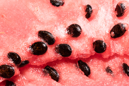 Close-up red fresh watermelon with black seeds. Healthy sweet tropical vegetable in detail, vibrant red colors.の写真素材