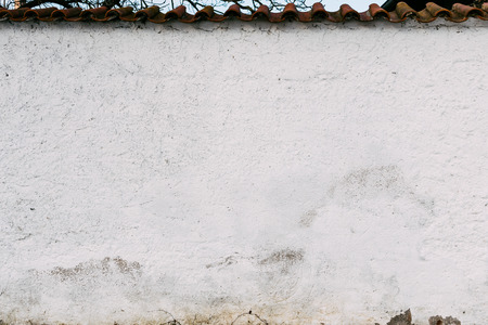 Pure white wall with texture. Blue sky with clouds at the top part.の写真素材