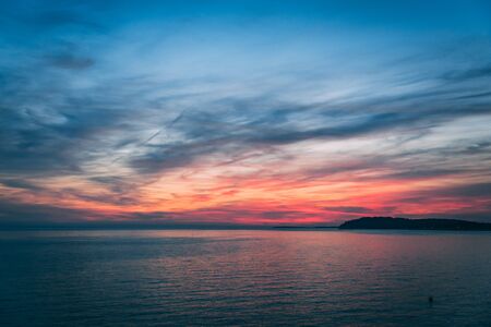 Sunset over the sea, colorful clouds, wide shot. Romantic picture full of colors.の写真素材