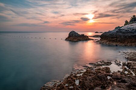 Sunset over the sea, colorful clouds, wide shot. Romantic picture full of colors.の写真素材