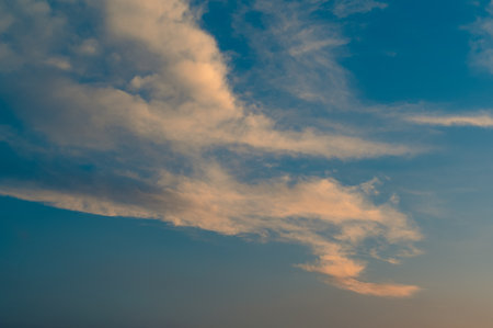 Beautiful summer sky full of clouds at sunset at golden hour. Interesting warm colors on the horizon.の写真素材