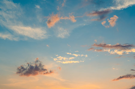 Beautiful summer sky full of clouds at sunset at golden hour. Interesting warm colors on the horizon.の写真素材