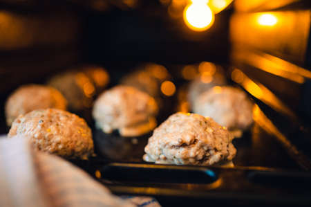 View into the oven on the baking tray for meatballs. Little light, light only from the oven. Shallow depth of field, blurred background.の写真素材