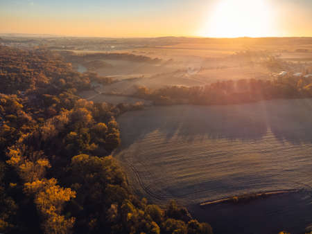 Aerial top-down view of autumn landscape at sunrise. There is a fine haze above the ground.の写真素材