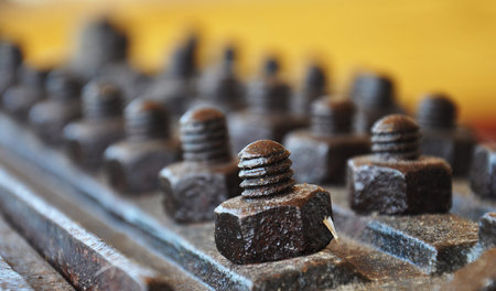 Old vintage rusty bolts with nuts on great metal plate. This image was captured in technical museum...