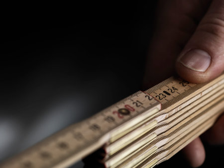 Close up wooden folding ruler with a hand