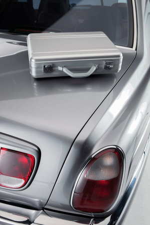 Briefcase from a business man on the car boot of a luxery car