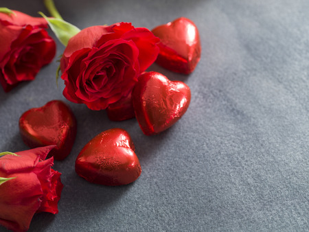 Chocolate hearts and red roses on a grey background. Valentines day backgroundの写真素材