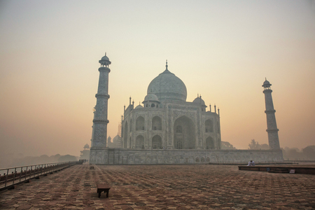 Agra, India. White marble Taj Mahal complex with minarets and walls through the haze and smog from Agra Fort fortress UNESCO heritage behind Yamuna river in Agra, Indiaのeditorial素材