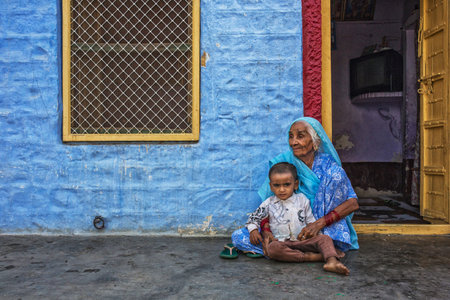 Portrait of old Indian woman in colorful ethnic attire with her grandson. Jaisalmer, Rajasthan,...