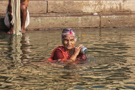 Unidentified Hindu woman pilgrim take bath in the Holy river Ganges at the ghats of Varanasi, Uttar Pradesh, Indiaのeditorial素材