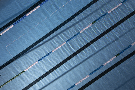 Water ripples on blue tiled swimming pool background. View from aboveの写真素材