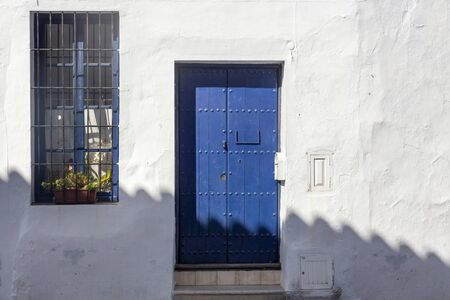 Vintage window and blue door on old traditional house in Andalusia, Spainの写真素材