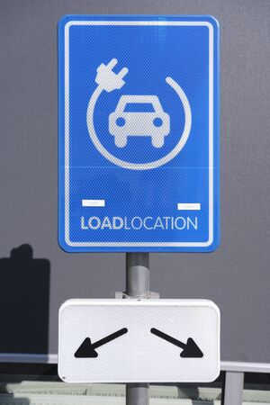 electrical charging station sign conveniently located next to a public parking lotの写真素材
