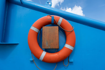 Orange float ring on a blue metal wall
