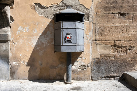 vintage black garbage can on a concrete wall background